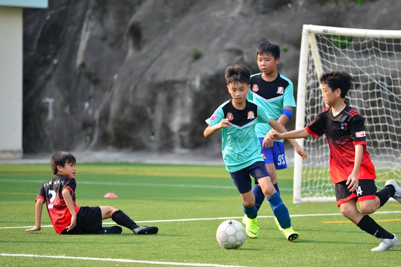 discover Boys playing a lively soccer match on a sunny soccer field, showcasing teamwork and sportsmanship.
