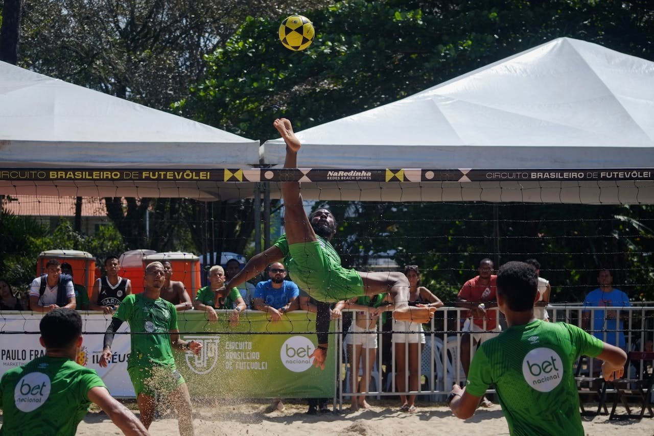 Action-packed futevôlei match in Ilhéus, Brazil, showcasing athletic skill and beach sports.