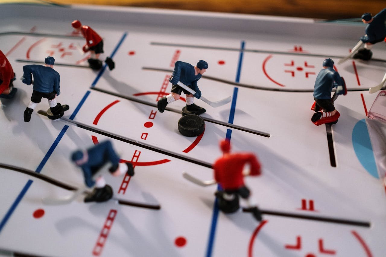 Closeup on a table hockey game showcasing figurines in motion on the playing field.